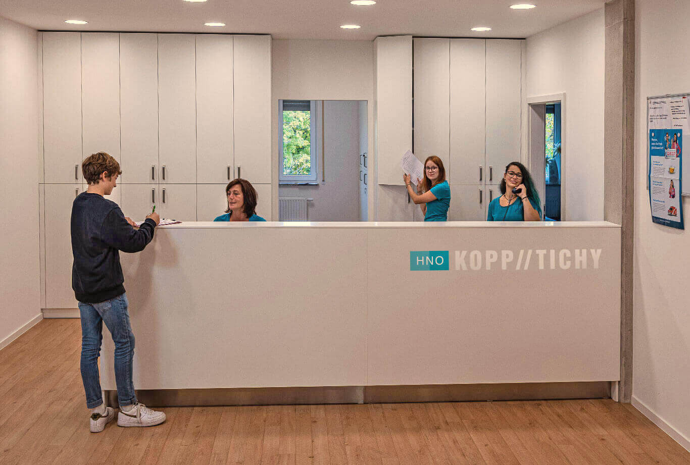 Reception counter with medical reception staff and a young patient