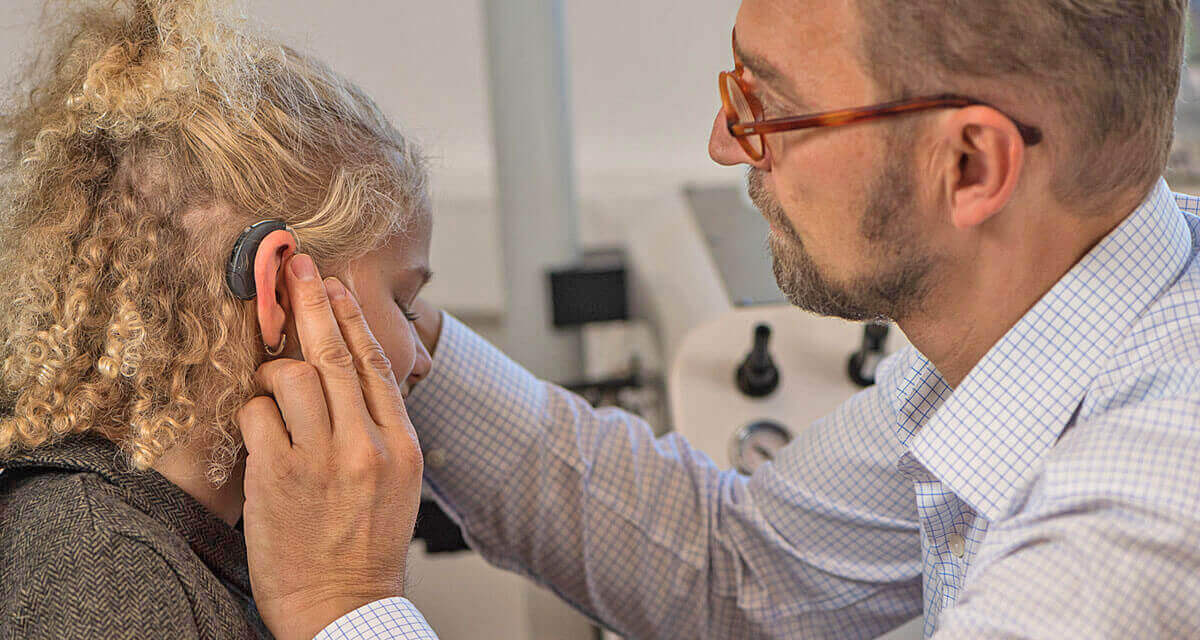 ENT doctor Martin Tichy with a young patient with hearing aid